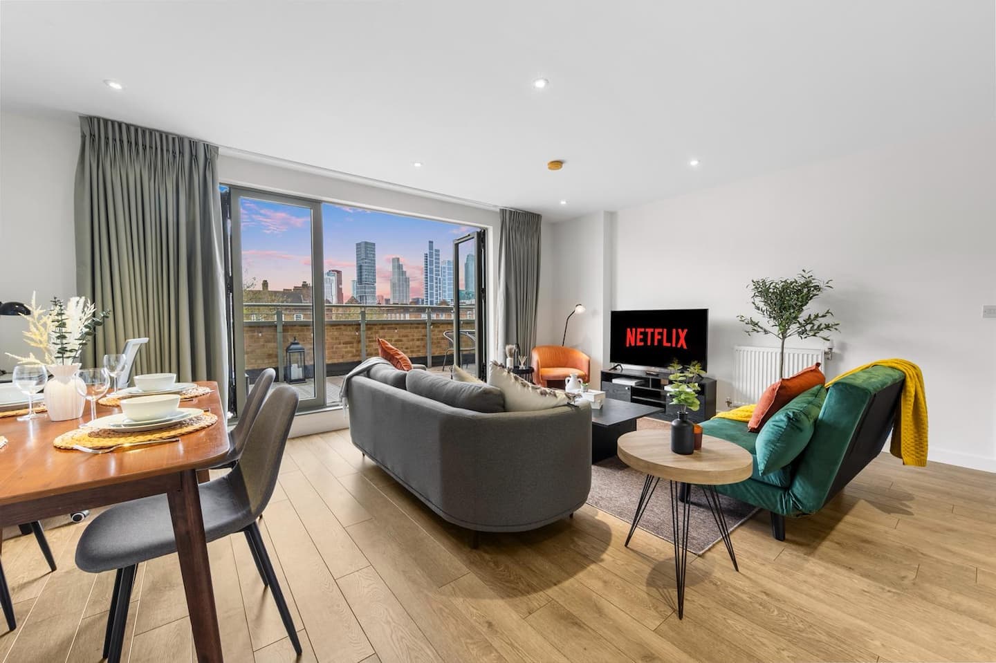 Open-plan living and dining room with skyline view through the terrace doors